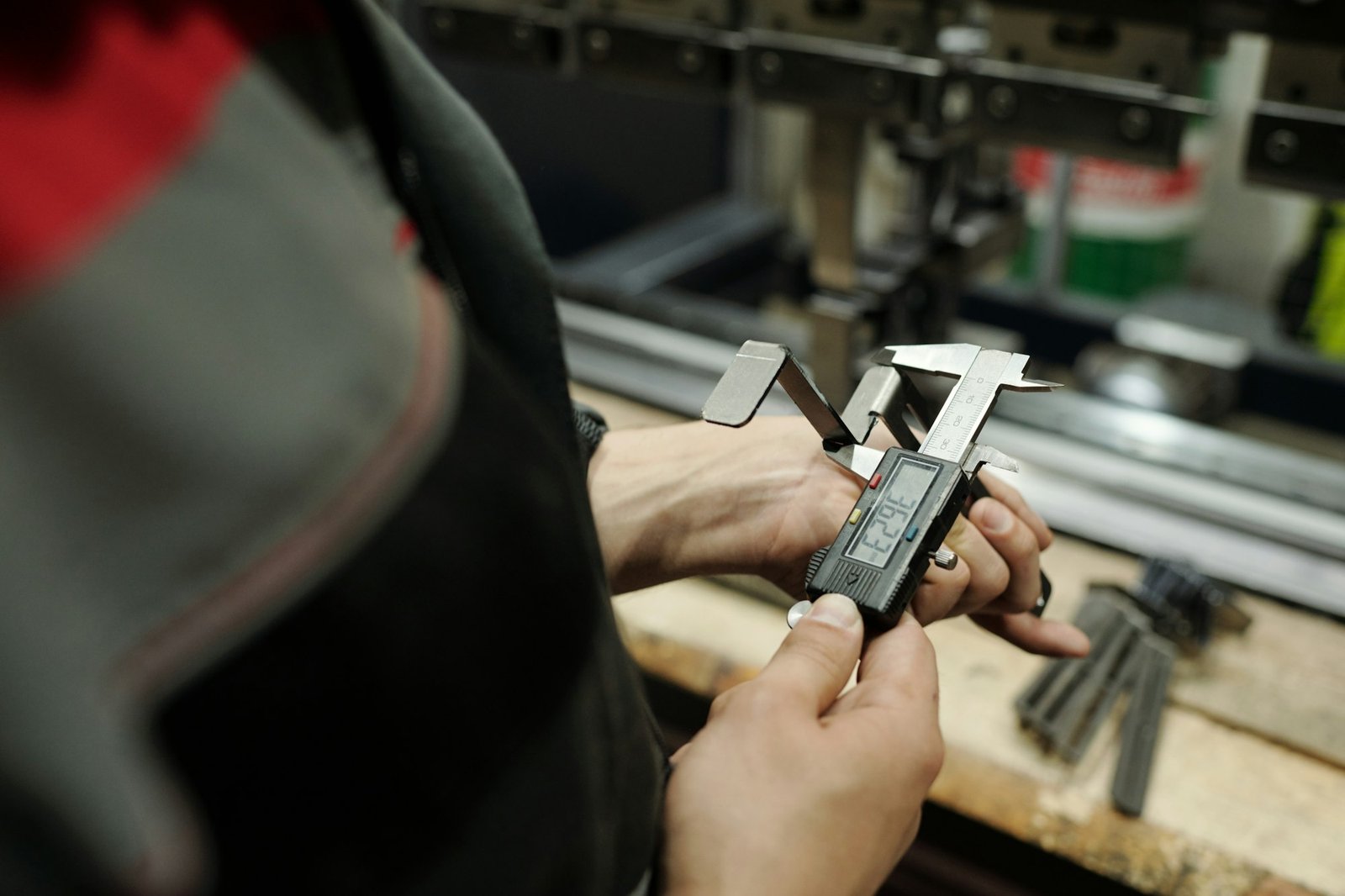 Hands of male engineer measuring detail produced from stainless steel