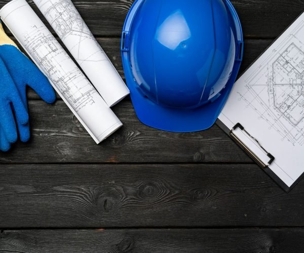 Hardhat, gloves and blueprints of a builder